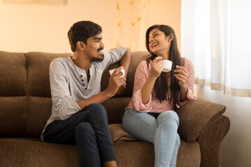 Fototapeta premium Cheerful young friends chatting on sofa at home.