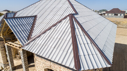 Modern roof. Roof covering. Roman profile. The roof of the house is covered with wavy gray tiles.