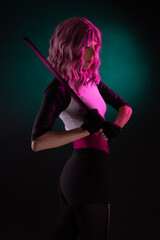 Punk rock sexy female assassin with pink hair wearing black holding a sword