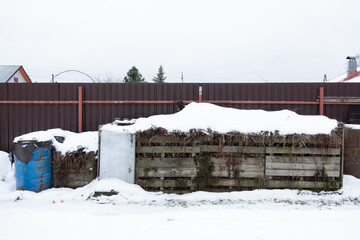 Very large three section wooden compost box standing garden in winter at countryside for ecological...