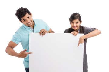 Cheerful cute young couples holding white board isolated on white.