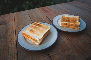 Toasts bread on a white dish on a wooden floor