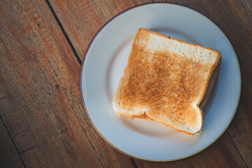 Toasts bread on a white dish on a wooden floor