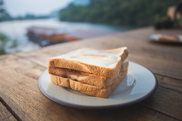 Toasts bread on a white dish on a wooden floor
