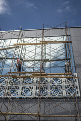 Modern glass building in scaffolding against the sky