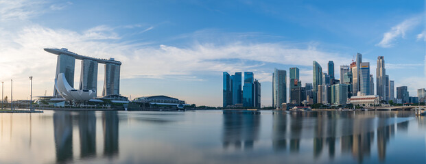 Ultra wide panorama image of Singapore skyscrapers illuminated by morning sunlight early in the...