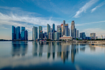 Fototapeta na wymiar Wide panorama image of Singapore skyscrapers illuminated by morning sunlight early in the morning.