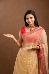 Indian young girl greeting in Traditional saree studio shot.