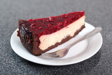 Cheesecake with chocolate crumb base topped with raspberry jelly