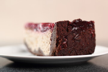 Cheesecake with chocolate crumb base topped with raspberry jelly