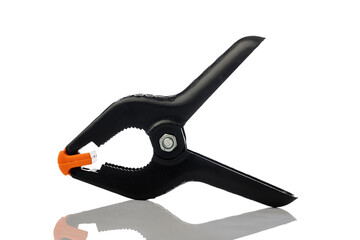 Black plastic spring clamp isolated on white.