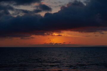 A beautiful orange sunset and looming dramatic clouds in the Mediterranean Sea.