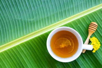 herbal healthy drinks hot honey lemon tea health care for cough sore with flower marigolds of lifestyle arrangement flat lay style on background banana leaf
