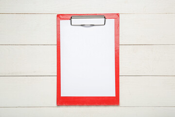 Clipboard with blank paper sheet on wooden background