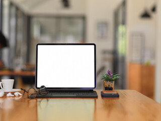 Wooden table with digital tablet, accessories, eyeglasses and plant pot