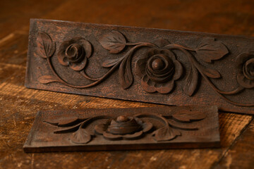 Wood carving. Woodworking. Ancient pattern of flowers and leaves carved on a wooden background close up macro