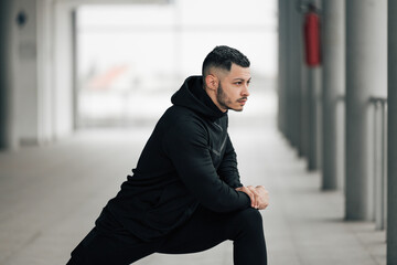 Male stretching legs before leg day training.