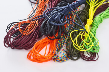 Coils of assorted paracords on white background