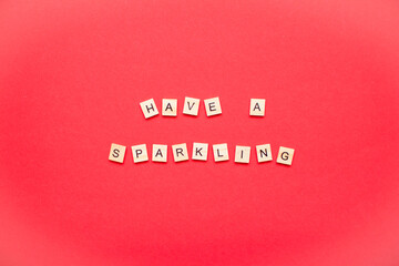 Fototapeta na wymiar Have a sparkling. The inscription from wooden blocks on a bright red background. New Year. Christmas.