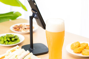 スマートフォンでリモート飲み会をする男性