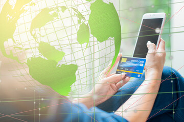 Woman doing business with a smartphone and credit card with World map. Copy space