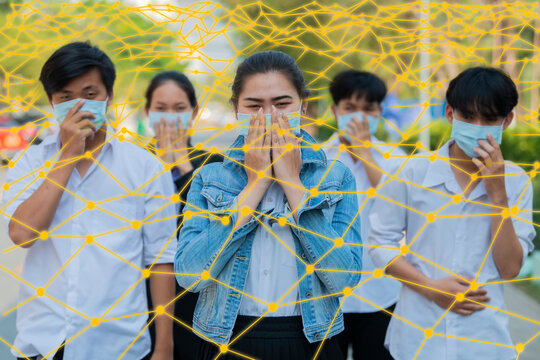 Concept of A medical mask protects against the spread of coronavirus COVID-19. Human protection from outbreak. Group of Asian people in protective masks and yellow lines network.