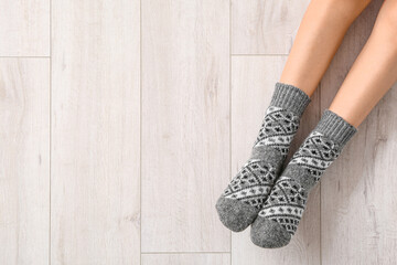 Legs of young woman in socks on wooden background