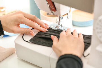 Female tailor making protective masks in workshop