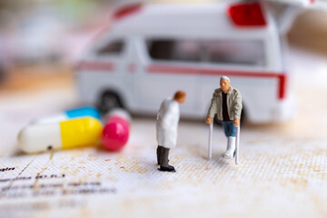 Miniature people : Doctor and patient standing with Capsule and Ambulance. Healthcare and medical concepts.