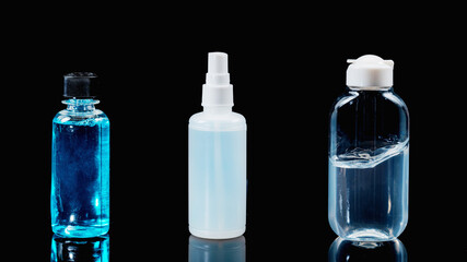 Disinfectants and Sanitizers on black background with reflection. Alcohol Spray, Hand Sanitizer Gel and Mouthwash Liquid.