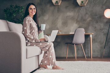 Profile photo of nice sweet girl hold cup write laptop wear spectacles pijama at home on sofa
