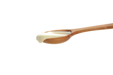Spoon with condensed milk isolated on white background