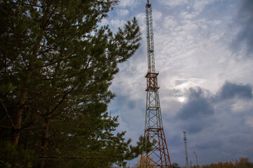 TV and radio broadcasting tower in the autumn forest