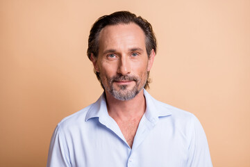 Photo of mature handsome bristled guy look camera wait wear white shirt isolated beige color...