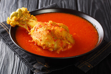 Central American turkey soup in red vegetable broth with spices close-up in a bowl on the table. horizontal