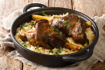 Lamb haneeth is a traditional dish with basmati rice close-up in a frying pan on the table. horizontal