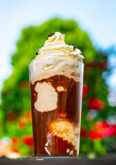 Iced coffee with whipped cream and vanilla ice cream on a hot summer day.