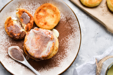 Sweet cottage cheese pancakes. Condensed milk. Festive sweet breakfast or lunch. Light background. Top view