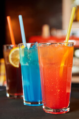 Multicolored alcoholic and non-alcoholic cocktails with ice and straws