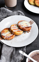Sweet cottage cheese pancakes. Condensed milk. Festive sweet breakfast or lunch. Dark grey background. Vertical view