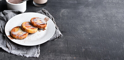 Sweet cottage cheese pancakes. Condensed milk. Festive sweet breakfast or lunch. Dark grey background. Copyspace