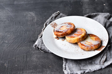 Sweet cottage cheese pancakes. Condensed milk. Festive sweet breakfast or lunch. Dark grey background. Copyspace