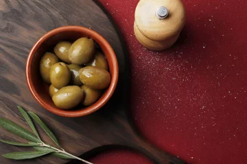 Foto op Plexiglas Bowl with green olives on a red table, space for text. © PANDA