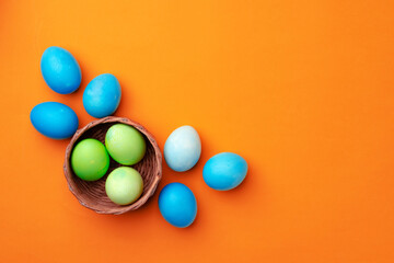 Easter eggs in a nest on orange background