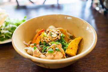 Mi Quang: is a Vietnamese noodle dish that originated from Quang Nam Province in central Vietnam. Mi quang and raw material as pork meat, salad, vegetable, chilli, lemon, yellow noodle, dried shrimp.