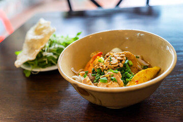 Mi Quang: is a Vietnamese noodle dish that originated from Quang Nam Province in central Vietnam. Mi quang and raw material as pork meat, salad, vegetable, chilli, lemon, yellow noodle, dried shrimp.