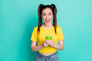 Portrait of impressed brunette nice girl hold telephone wear t-shirt isolated on blue color...