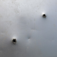 bullet ragged hole in sheet metal wall or door