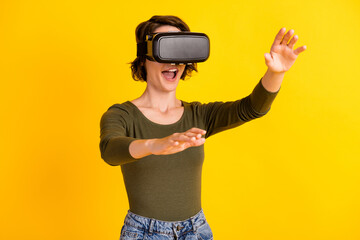 Crazy girl hold hands empty space look in illusion vr goggles wear jeans jumper isolated on bright...