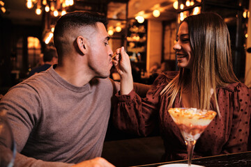 Couple sharing dessert and enjoying date together.